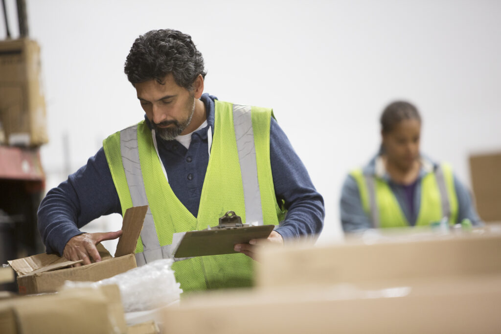 Two workers on the shipping line at warehouse