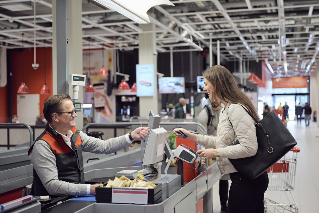 Cashier talking to shopper at checkout counter