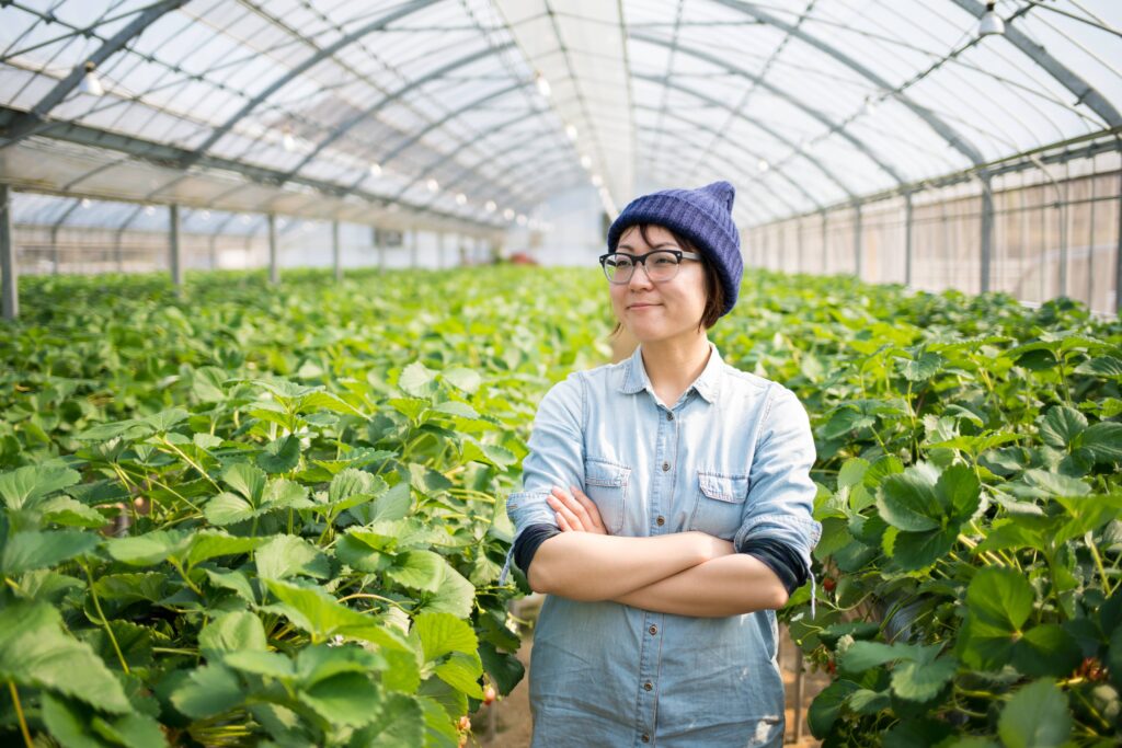 Confident farmer standing in plant nursery