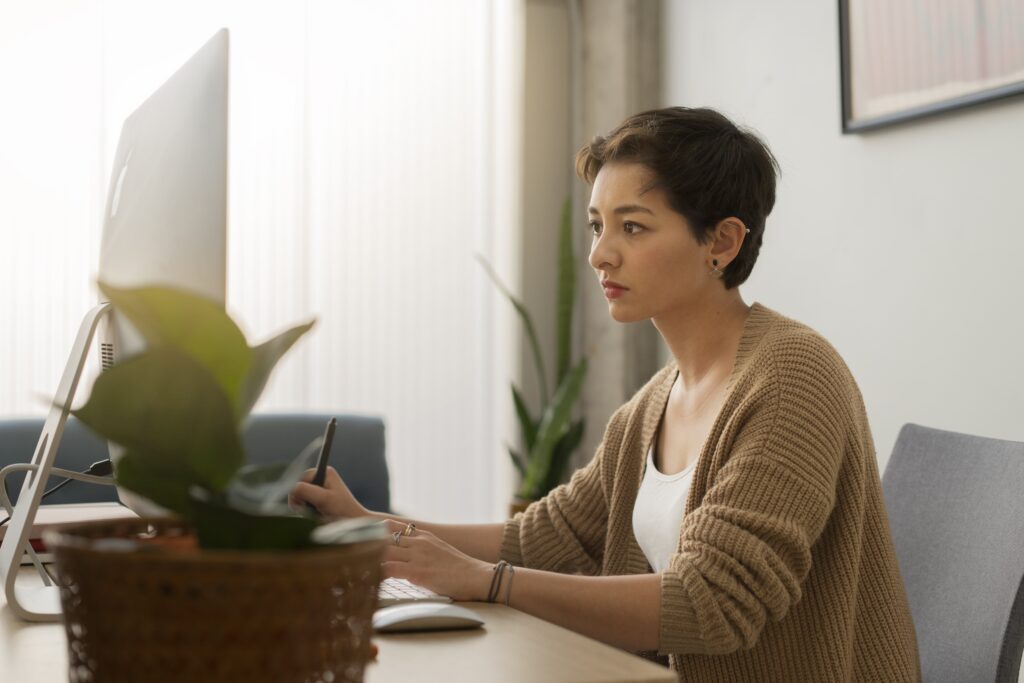 Person busily taking notes in front of computer