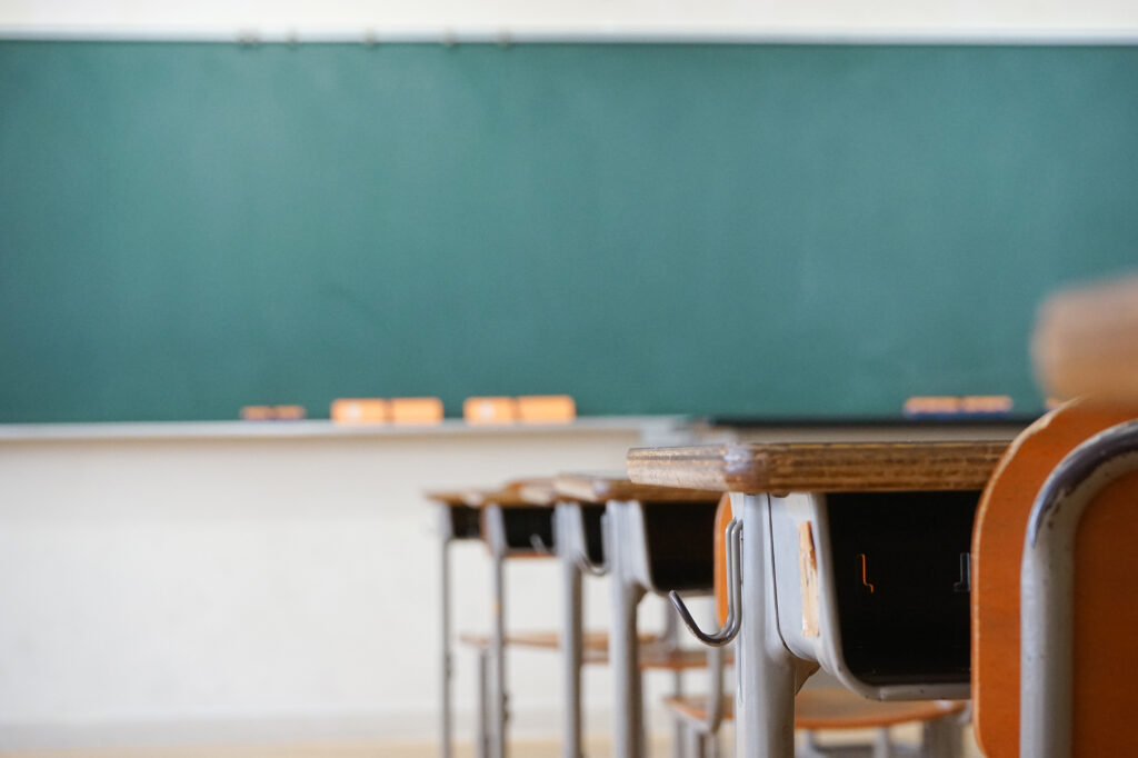 Empty classroom with rows of desks and blackboard