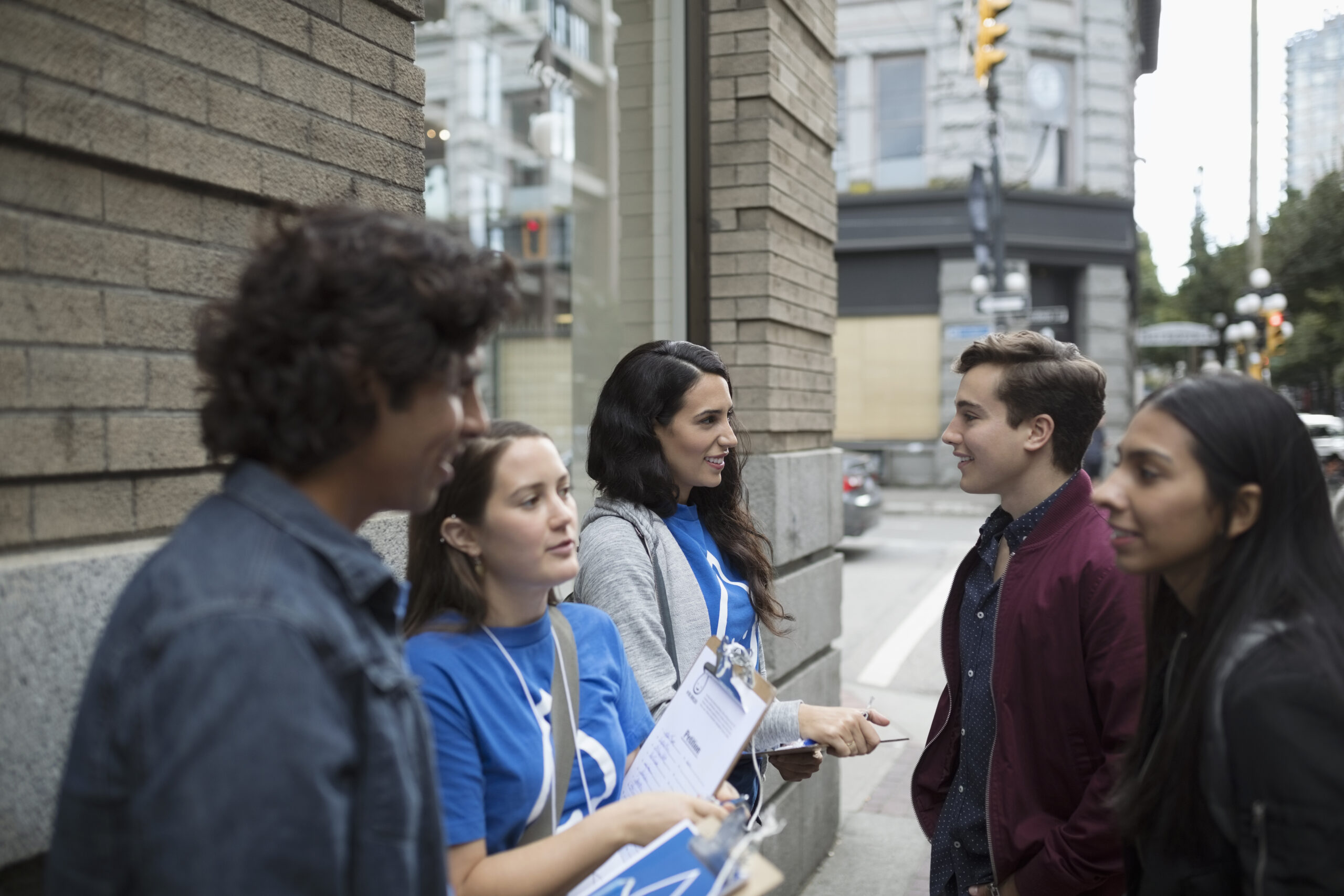 Jeunes adultes politiques démarchant avec des presse-papiers