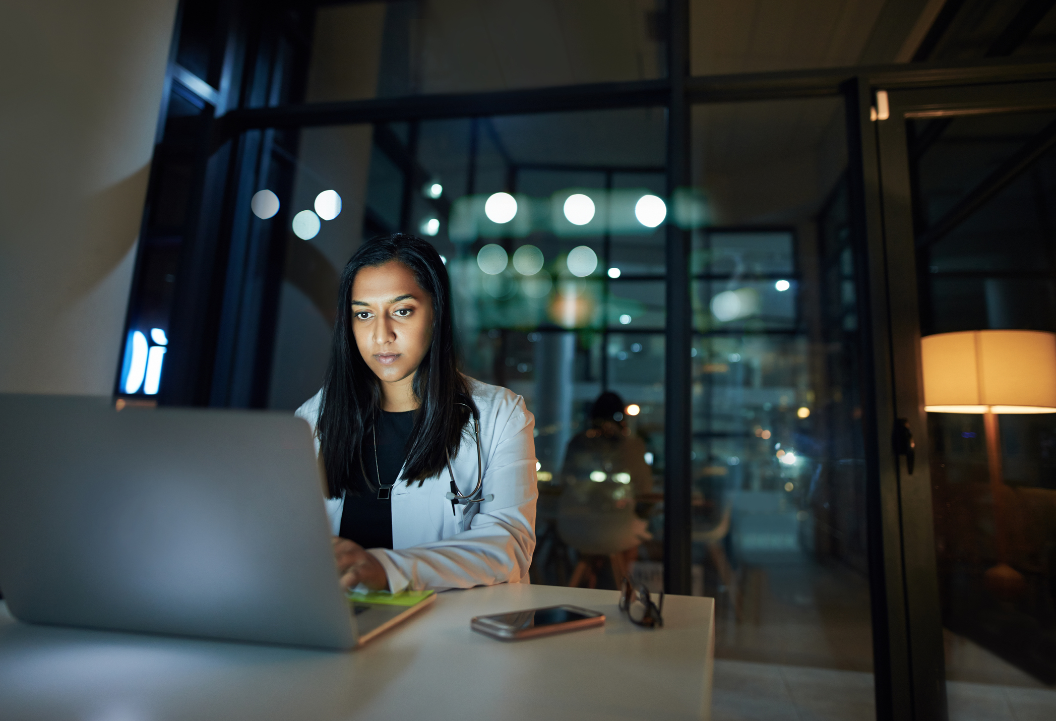 Person using a laptop in an office at night