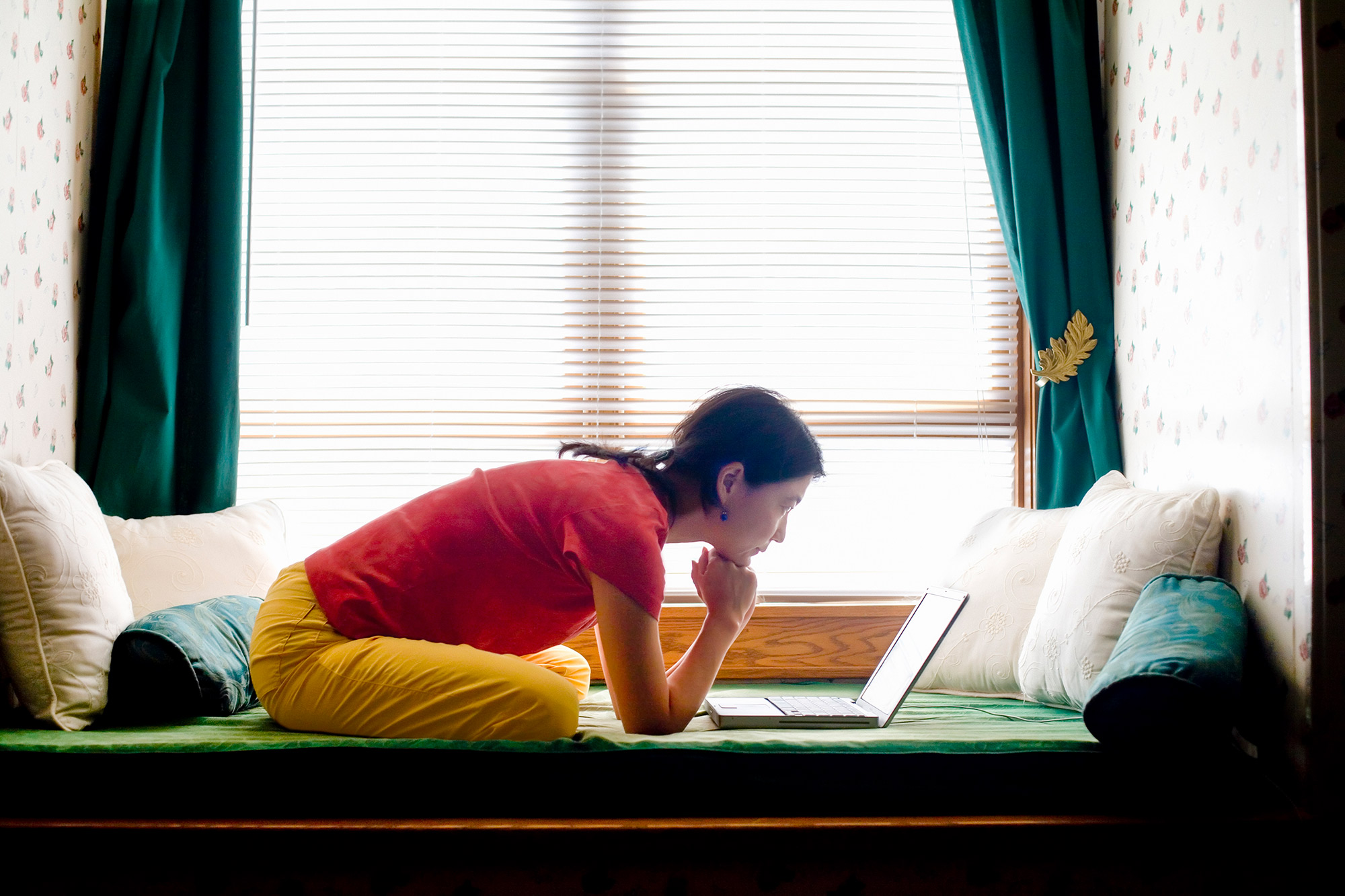 Person leaning over laptop while working from home