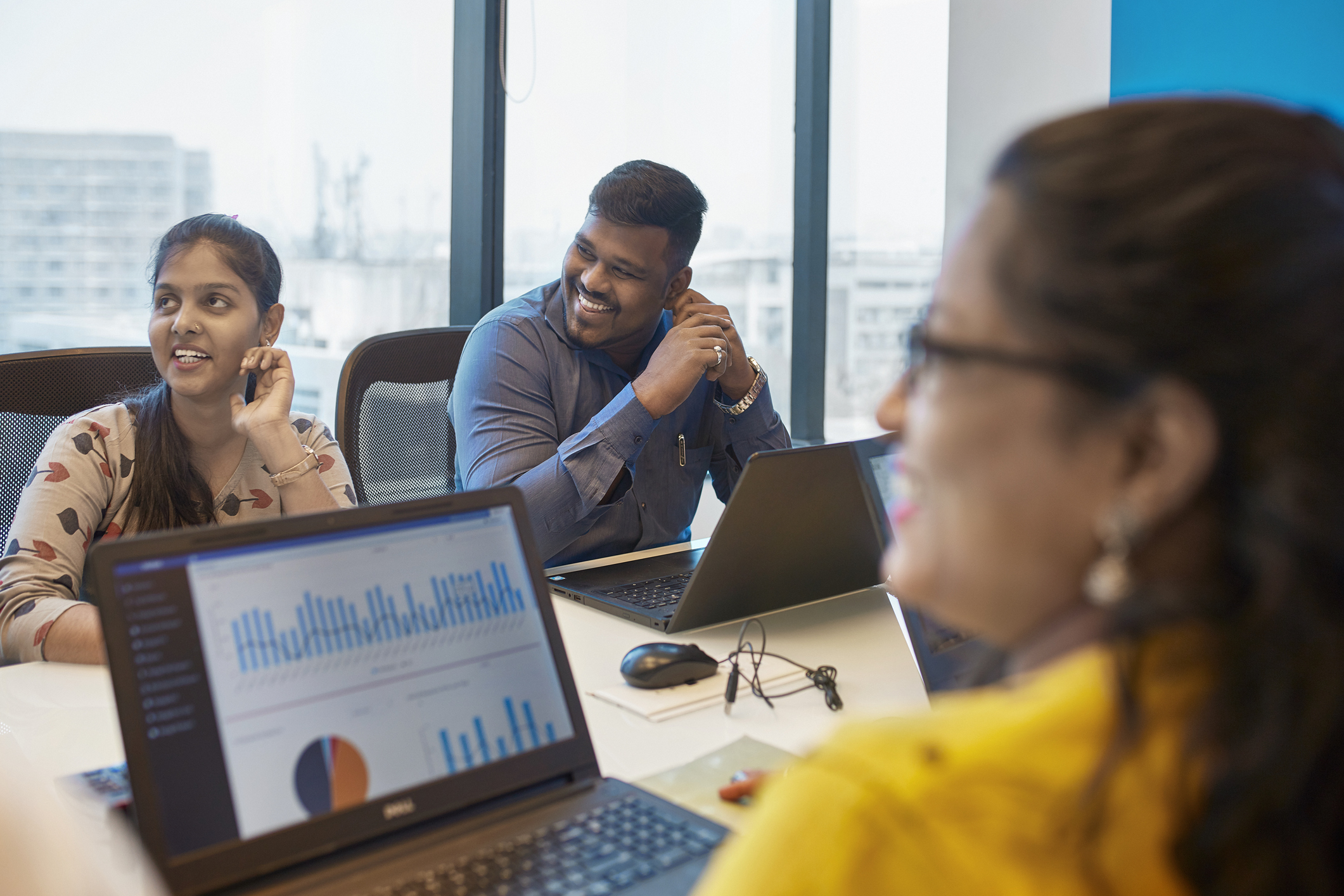 Smiling professionals sitting at conference table during meeting.