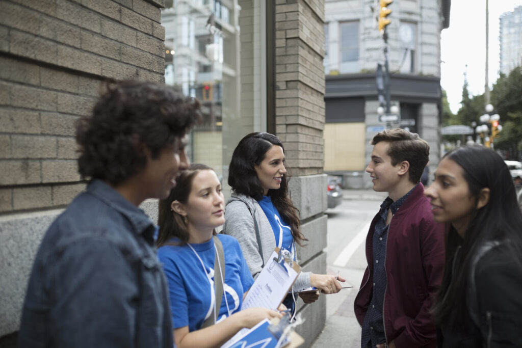 Political young adults canvassing with clipboards