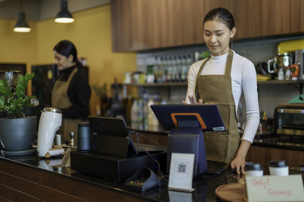 Retail cashier and barista behind the counter at cafe