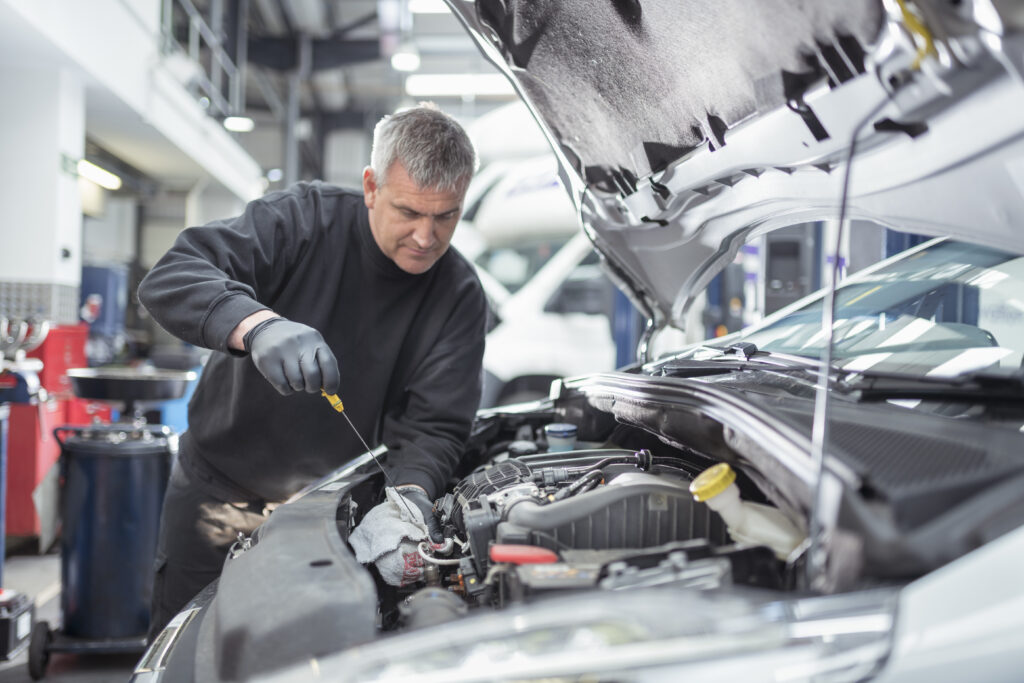 Mechanic checking oil in garage