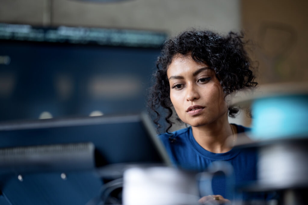 Data analyst reviewing systems technology on computer